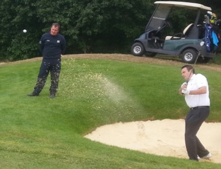 Birchwood Park Golf Centre Head Professional Stephen Lee plays from the remodeled bunker on hole eight of the Main Course with course manager Mark Bell watching