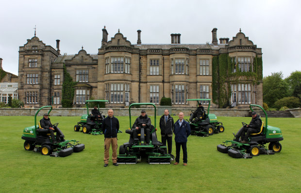 Matfen Hall Golf Club course manager Derek Millar, John Deere territory manager Richard Charleton and Greenlay dealer principal Geoff Lowes (standing, left to right) with the greenkeeping staff and their new John Deere fleet in front of the Grade II listed 19th century country mansion.
