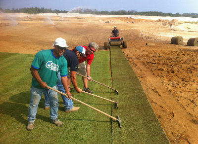 Big Roll installation: Green Grass crew members, Fabricio installing and Renato and Israel (front ) with David Doguet of Bladerunner Farms pulling the sod into place (photo courtesy Marcelo Matte, Green Grass Brazil)