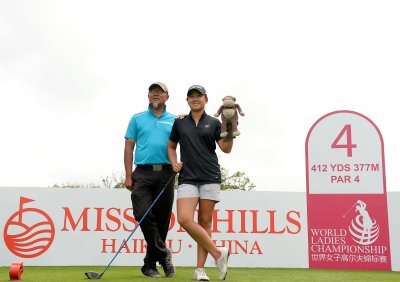 Jennifer Yan Jing, accompanied by her father and caddie Yan Ming, shows off her club head cover mascot, “Larry”, during practice for this week’s World Ladies Championship at Mission Hills Haikou in China (Paul Lakatos for Mission Hills)