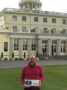 Stoke Park's director of golf, Stuart Collier, proudly displays the WLG plaque outside the club's iconic main building