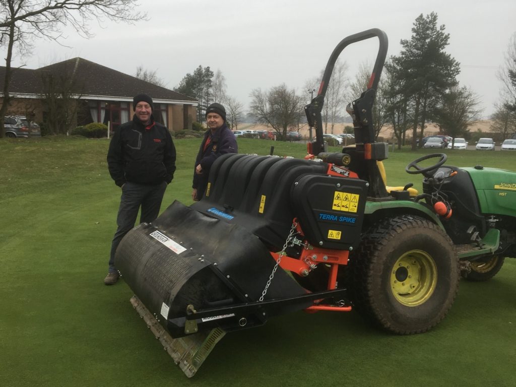 Simon Cotterill, (right), Head Greenkeeper at Market Drayton GC with Colin Goldfinch, Regional Manager at Burrows GM, Stafford together with the first delivered Wiedenmann Terra Spike SL after its launch at SALTEX and BTME